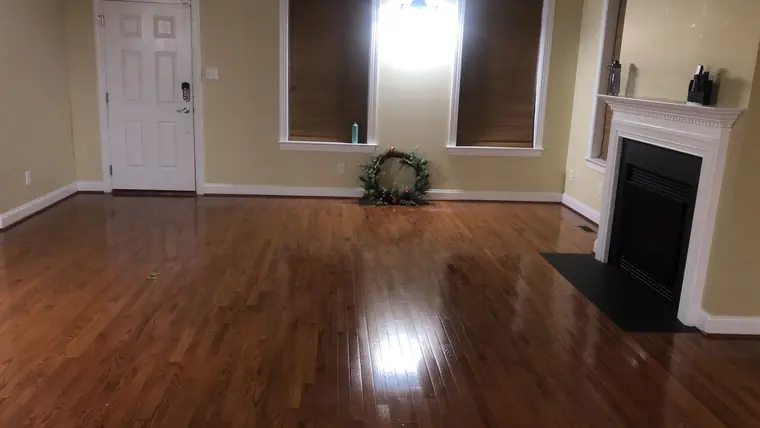 Empty room with polished hardwood floor after cleaning